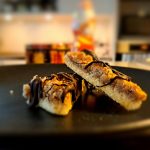 2 Nussecken auf einem Teller mit einer Keksdose und einem Schokoladennikolaus im Hintergrund